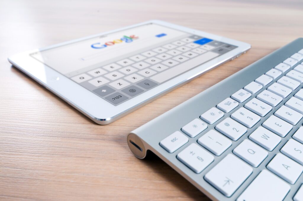 image of an iPad displaying the Google search page and a keyboard in the foreground. 